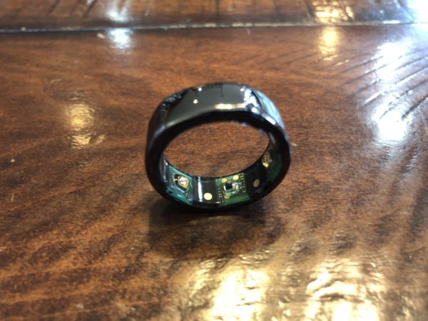 a black ring with a circuit board on a wooden surface