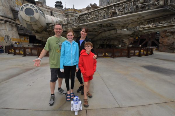 a family posing for a picture in front of a spaceship