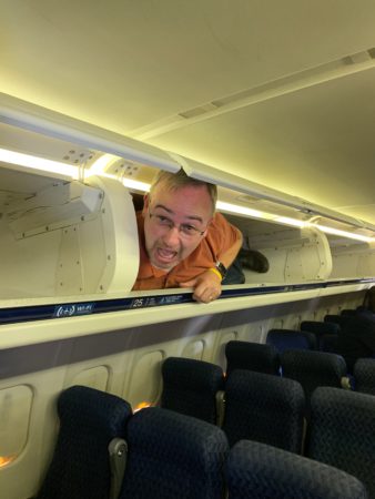 a man lying on a ledge in an airplane