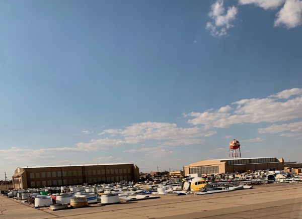 a large parking lot with many airplanes and buildings
