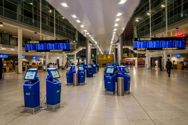 a group of blue electronic machines in a large airport