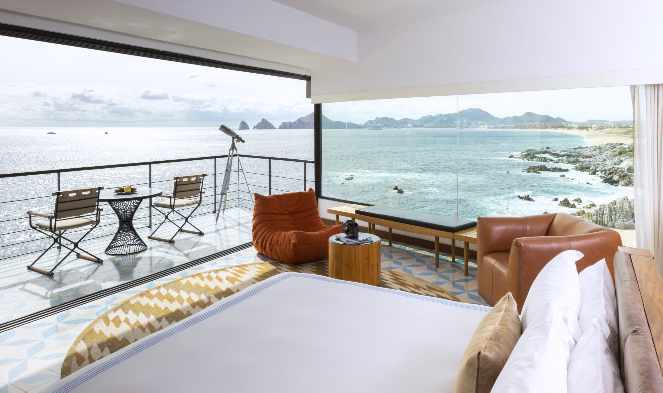 a room with a view of the ocean and a bed